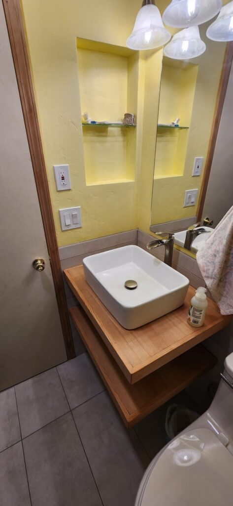 floating vanity in douglas fir and steel with niche to accomidate storage in a small space