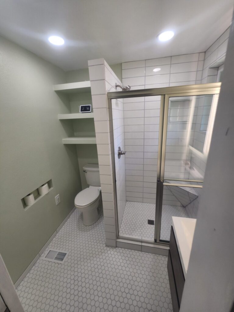 Built ins include tp niche, shelves, shower enclosure, shower seat, shoawer niche