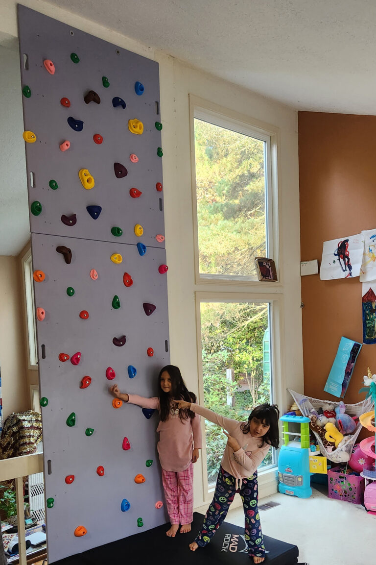 2 kids sizing up climbing wall handmade form plywood and dimensional lumber
